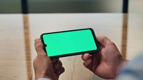 businessman hands watching chromakey device workplace. man holding mockup phone