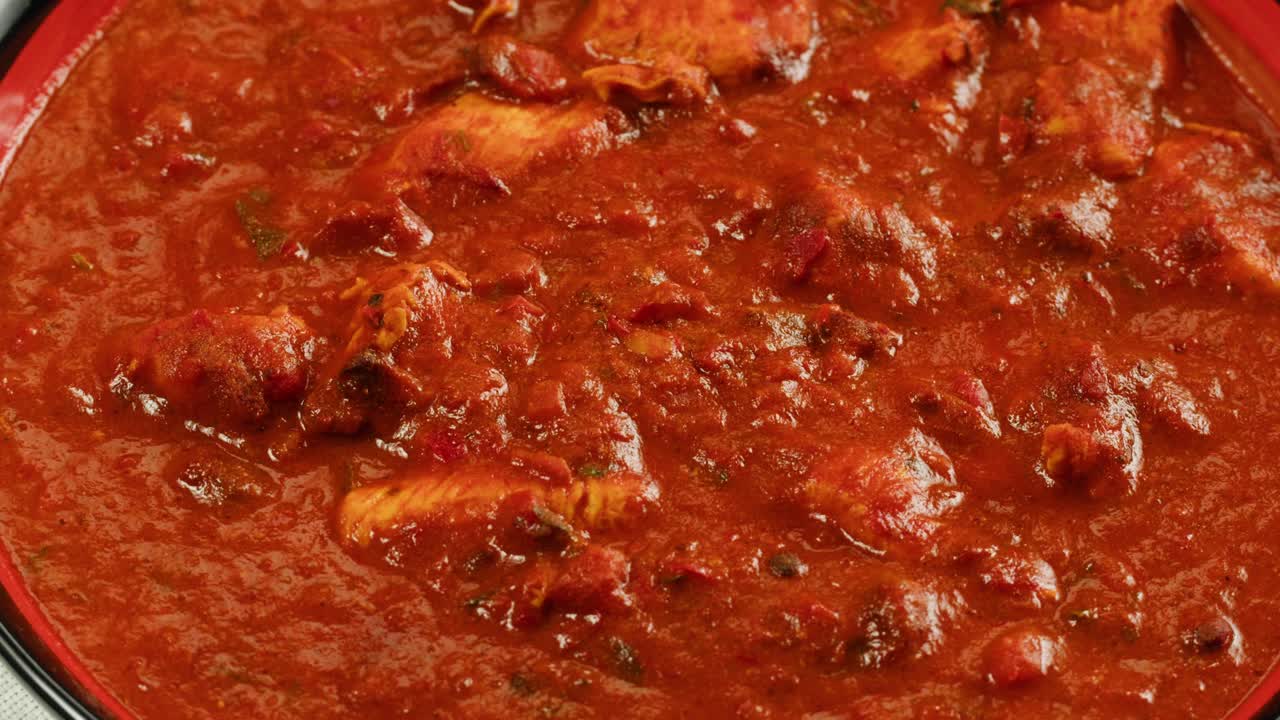 Assorted indian sri-lanka food set on wooden background. Dishes and appetisers of indeed cuisine, rice, lentils, paneer, samosa, spices, masala. Bowls and plates with indian food top view chicken. High quality 4k footage