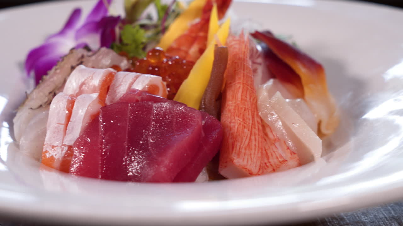 impresionante variedad de sashimi de sushi de colores en plato blanco, tazón de chirashi de arco iris, deslizador de cierre 4k