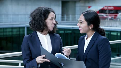 content businesswomen discussing papers