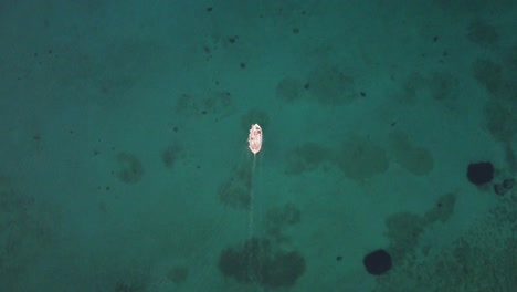 barco de pesca a vista de pájaro sobre agua cinematográfica azul