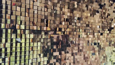 abstract background with flickering metallic or plastic particles wall, same size of shape of particles, real footage, a wall of golden sparkles spiked in the wind