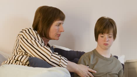 mature woman hugging her daughter on sofa