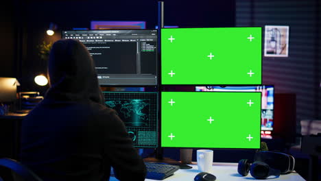 Close-up-of-hacker-running-code-in-apartment-on-PC-monitors