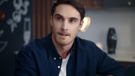 Portrait-of-focused-man-sitting-at-home-office.-Yung-guy-smiling-on-camera