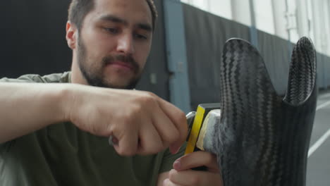athlete fixing prosthesis with wrench