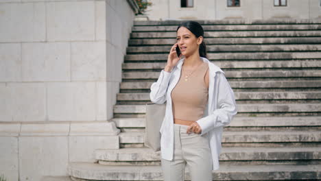 Relaxed-businesswoman-calling-phone-staircase-vertical.-Lady-talking-telephone