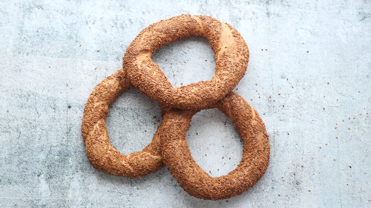 Three Sesame Simits on a Light Gray Surface