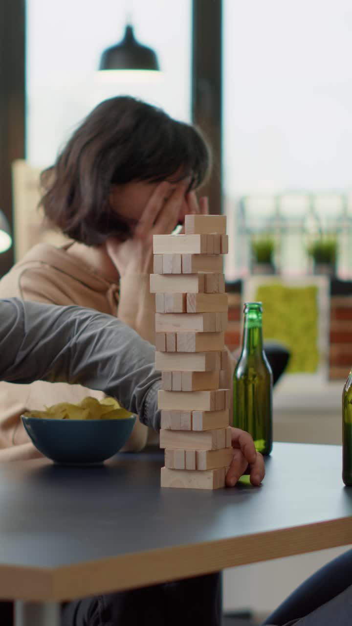 Persone che giocano a Jenga con birra e patatine