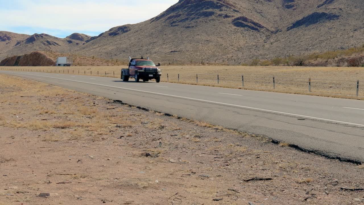 두 대의 색 트랙터 트레일러가 서부 텍사스 주간도로를 운전하고 있습니다.