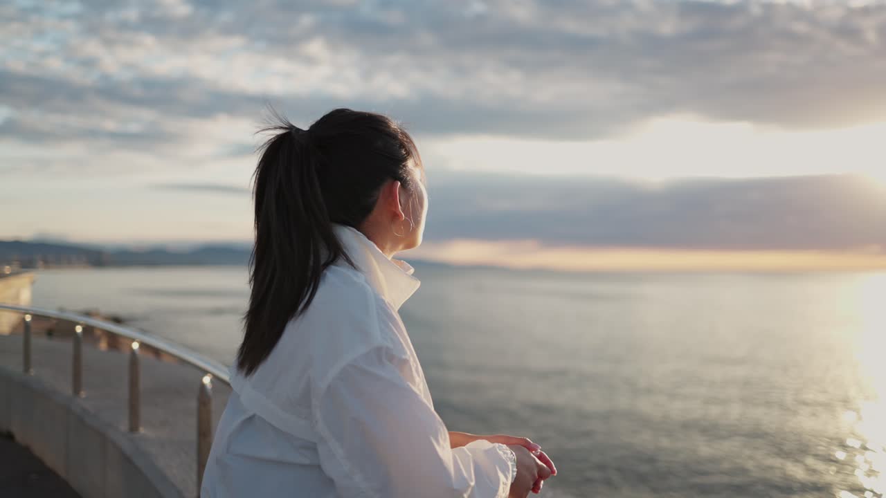 Jeune femme asiatique regardant la mer au lever du soleil
