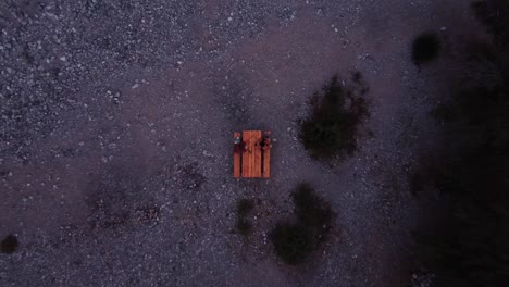 Two-people-sitting-on-a-wooden-table-in-a-picnic-area