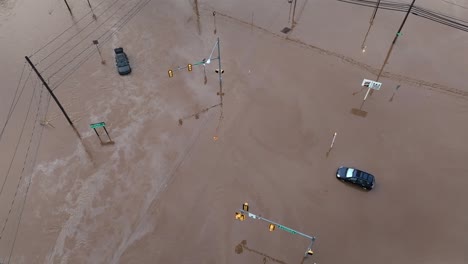 cars on street flooded by heavy rain in american town. sunken in mud. aerial top down shot. sunny day in pennsylvania after rainfall
