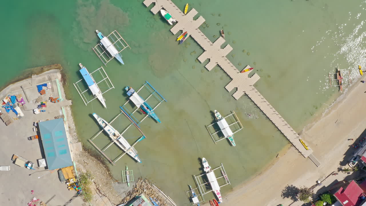 Aerial View of Tropical Bay with Outrigger Boats and Floating Dock