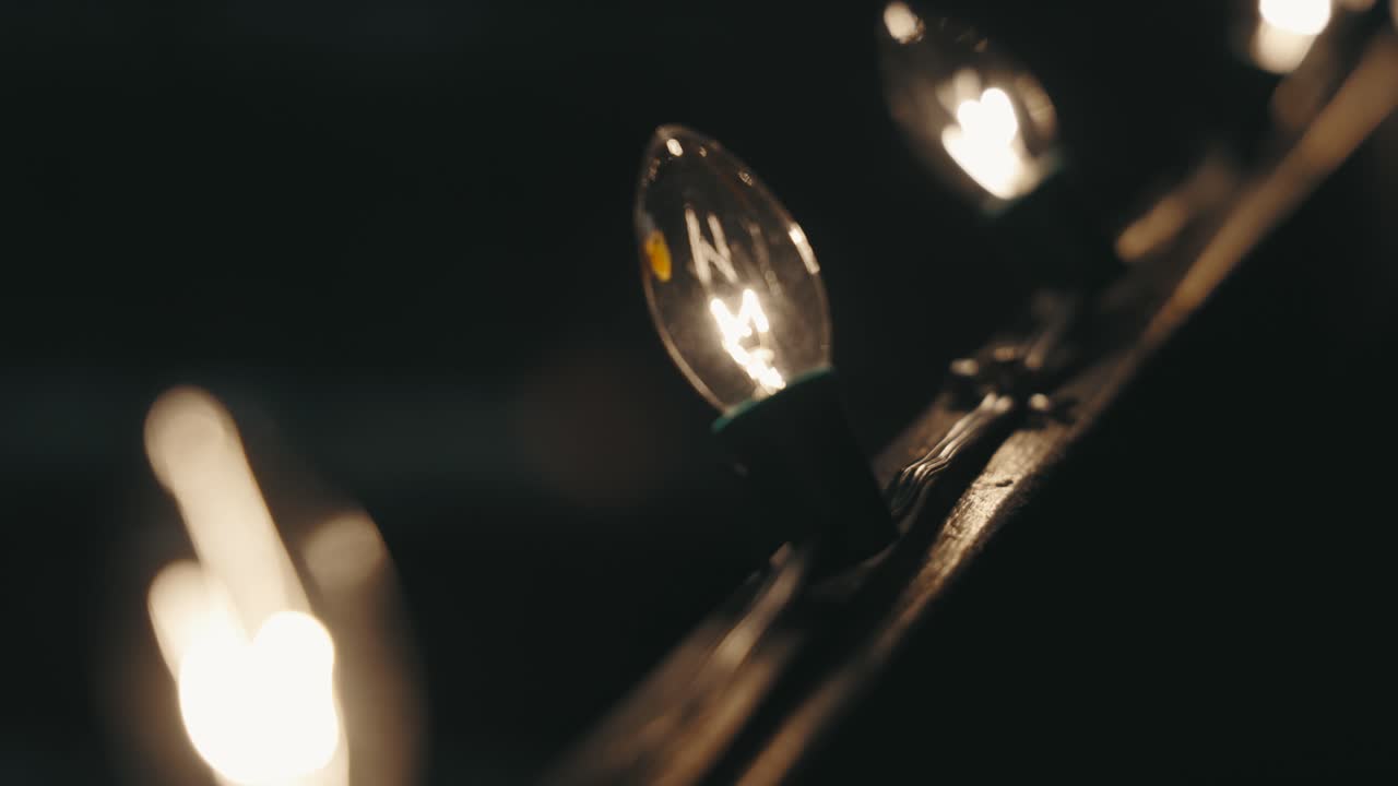 Vintage Incandescent Christmas string Lights with Large filament bulbs attached to a railing (4K)