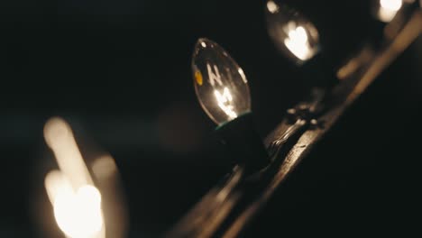 Vintage Incandescent Christmas string Lights with Large filament bulbs attached to a railing (4K)