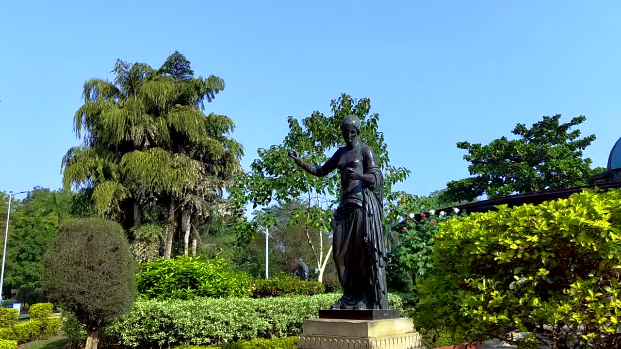 panela de cámara ancha en un jardín con mirador en el fondo de una estatua de mujer en sayaji baugh en la ciudad de vadodara, india