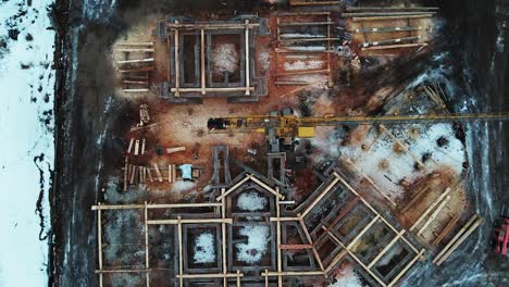 building in the wilderness: an aerial view of a log-home construction in progress in the winter of british columbia, canada