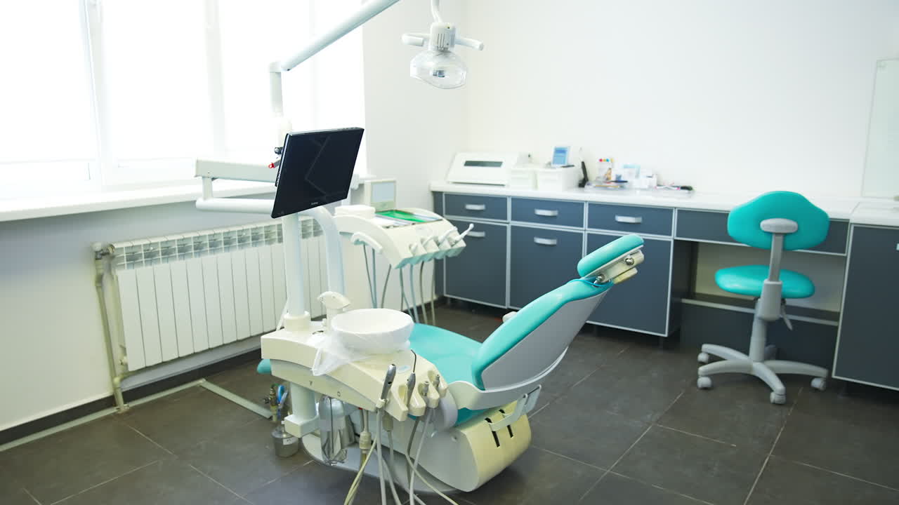 Medical office of dentistry with modern equipment and tools. Light clean room with desk and sofa for comfort of patients and doctors.