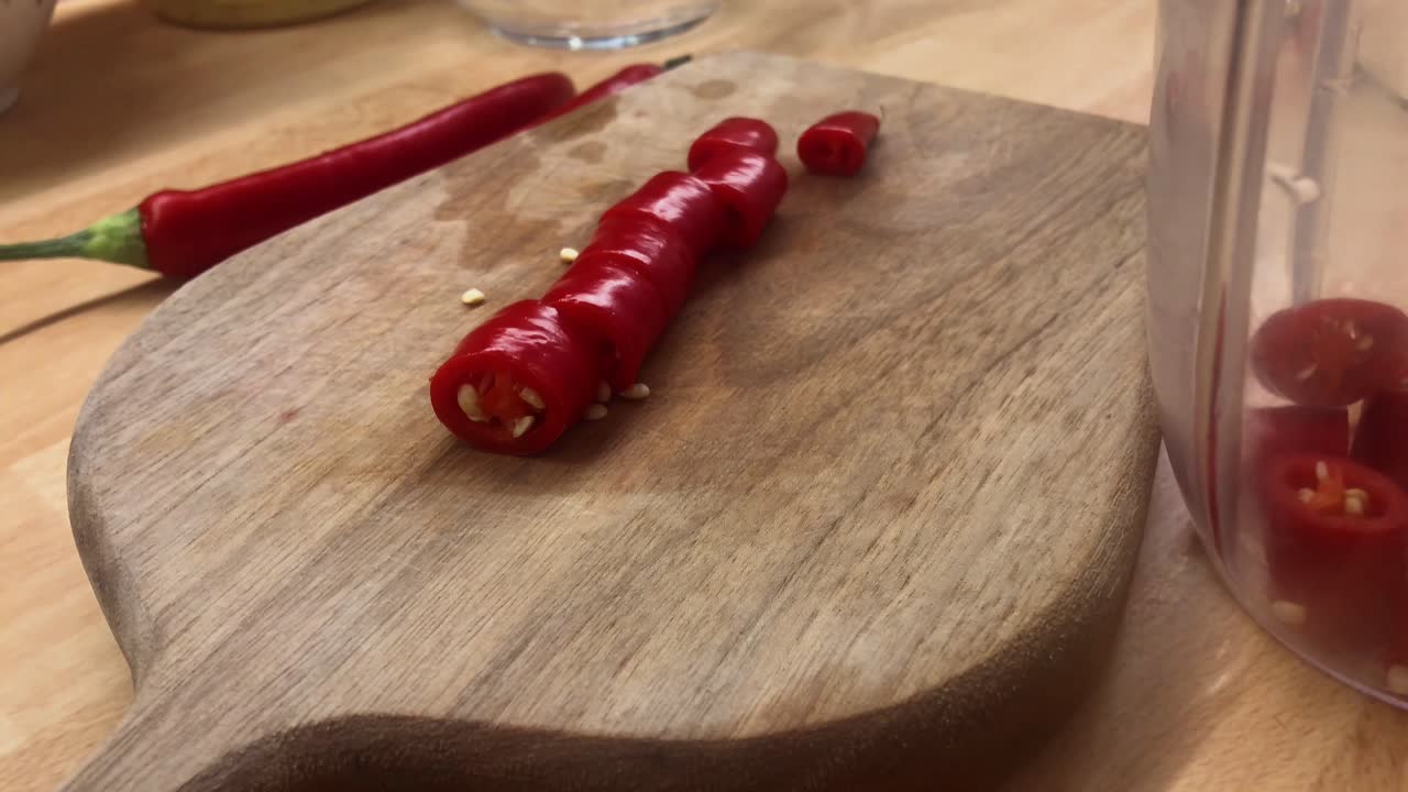 Close-up Hand Preparing Fresh Red Chili Pepper Slices