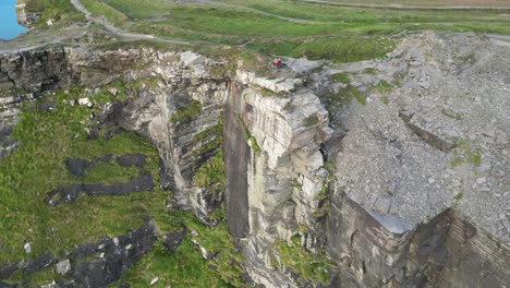 drone shot of two people sitting on the cliffs of moher at sunset