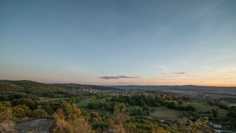 Bewegender-Zeitraffer-Eines-Sonnenuntergangs-über-Bewaldeten-Hügeln-Und-Dörfern