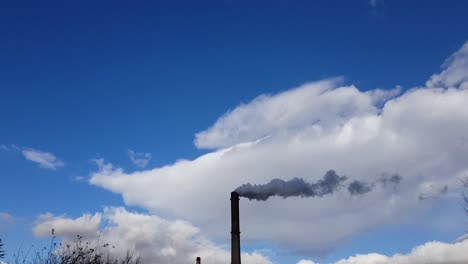 factory chimney emit dark smoke with blue sky and clouds in background at daytime