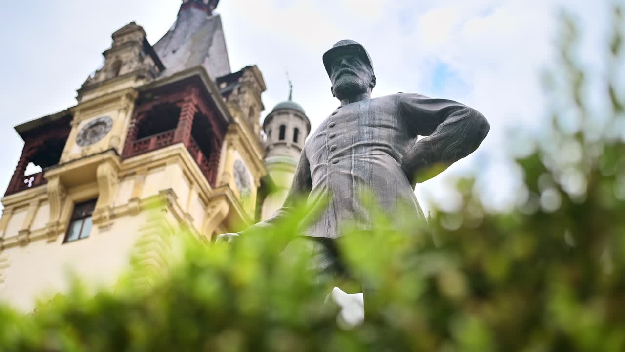 Statua di Re Carol al Castello di Peleș in Romania. Castello sullo sfondo