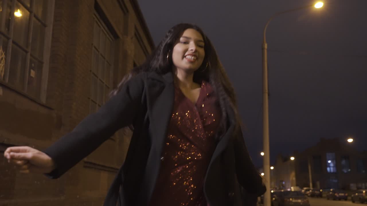 Camera focuses on a young girl in elegant clothes holding a sparkler and celebrating New Year's Eve