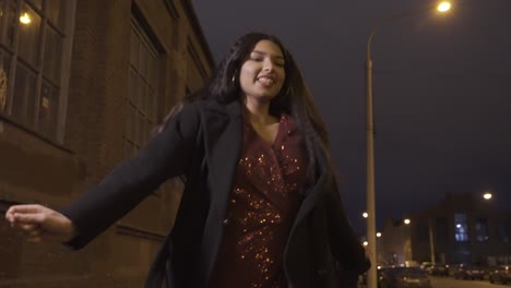 Camera focuses on a young girl in elegant clothes holding a sparkler and celebrating New Year&#039;s Eve