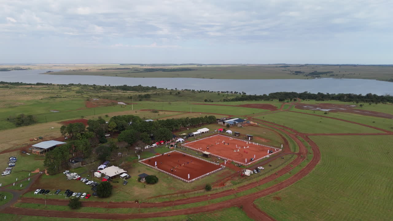 Aerial panorama view of an equestrian sports center with horse arenas surrounded by open countryside.