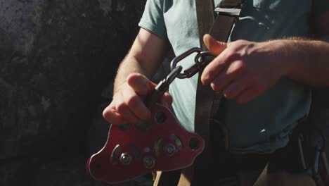 Young-Caucasian-man-fastening-zip-lining-harness