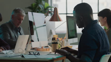 diverse small business team working late using computer technology in creative office workspace