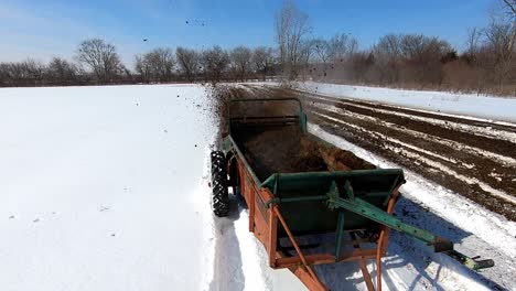 pulled fertilizing machine running on snowscape agricultural farmland in southeast michigan