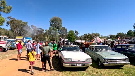 la gente se reúne alrededor de coches clásicos en un evento