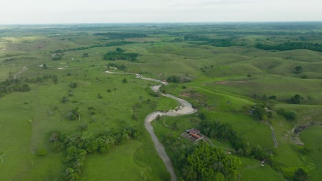 Lush-green-hills-and-a-winding-river-in-florencia,-colombia,-aerial-view