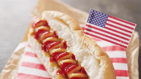 video of hot dog with mustard and ketchup with flag of usa on a black surface