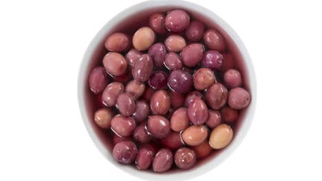 animation of red olives in bowl over white background