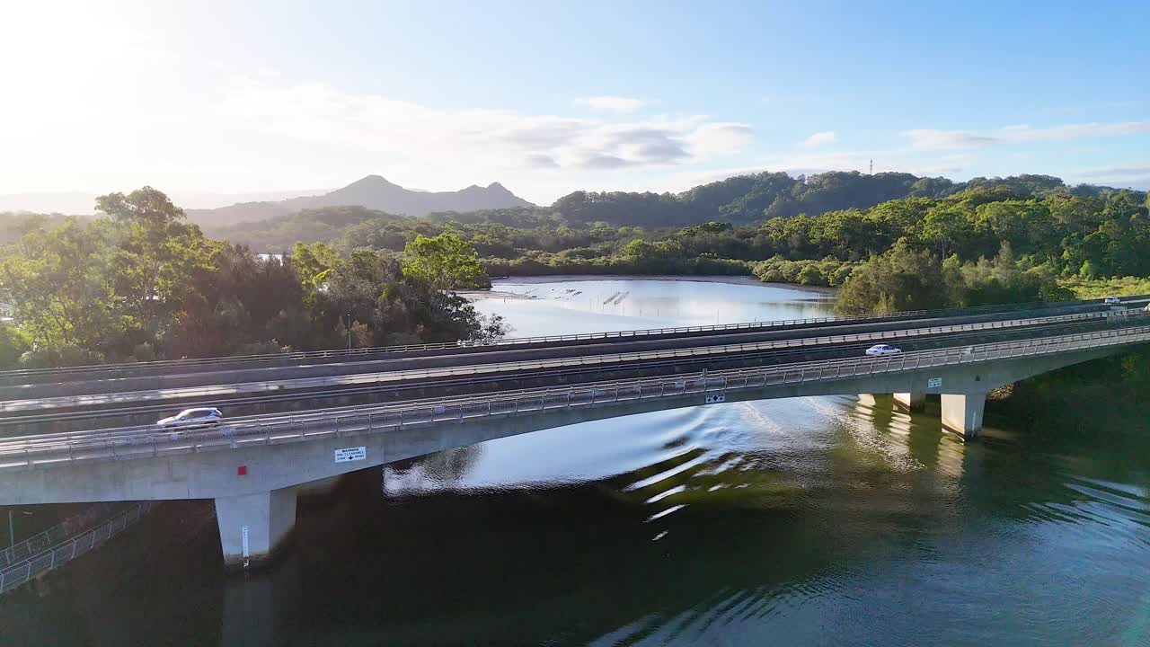 경치 좋은 강 풍경 을 가로지르는 다리 를 건너는 차량 들