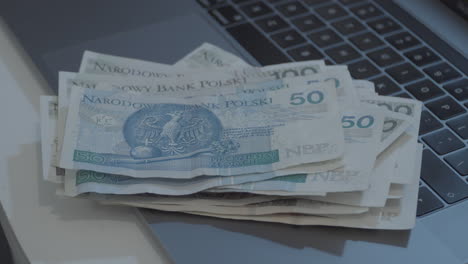 Ein-Stapel-Polnischer-Banknoten-Liegt-Auf-Einer-Laptoptastatur