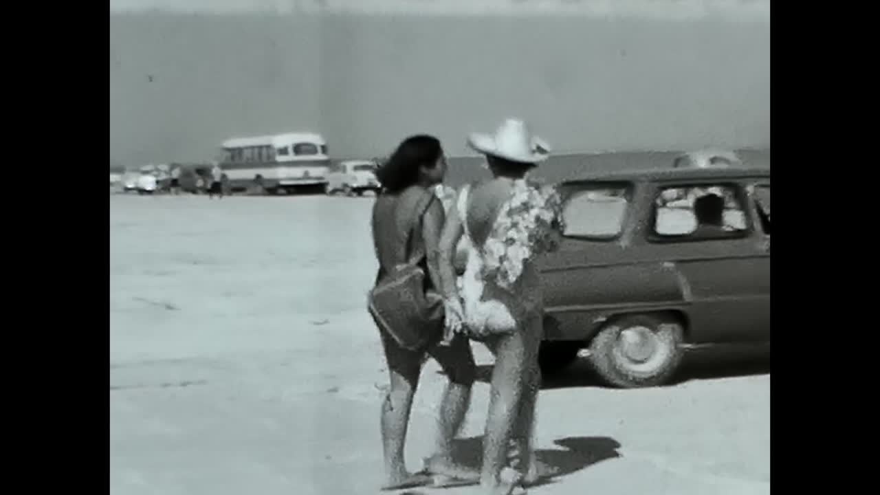 Woman Resting on Sandy Beach, Enjoying the Sun and Surf. CIRCA USSR 1970: A woman relaxing on top of a sandy beach, basking in the warmth of the sun and listening to the calming sound of the waves.