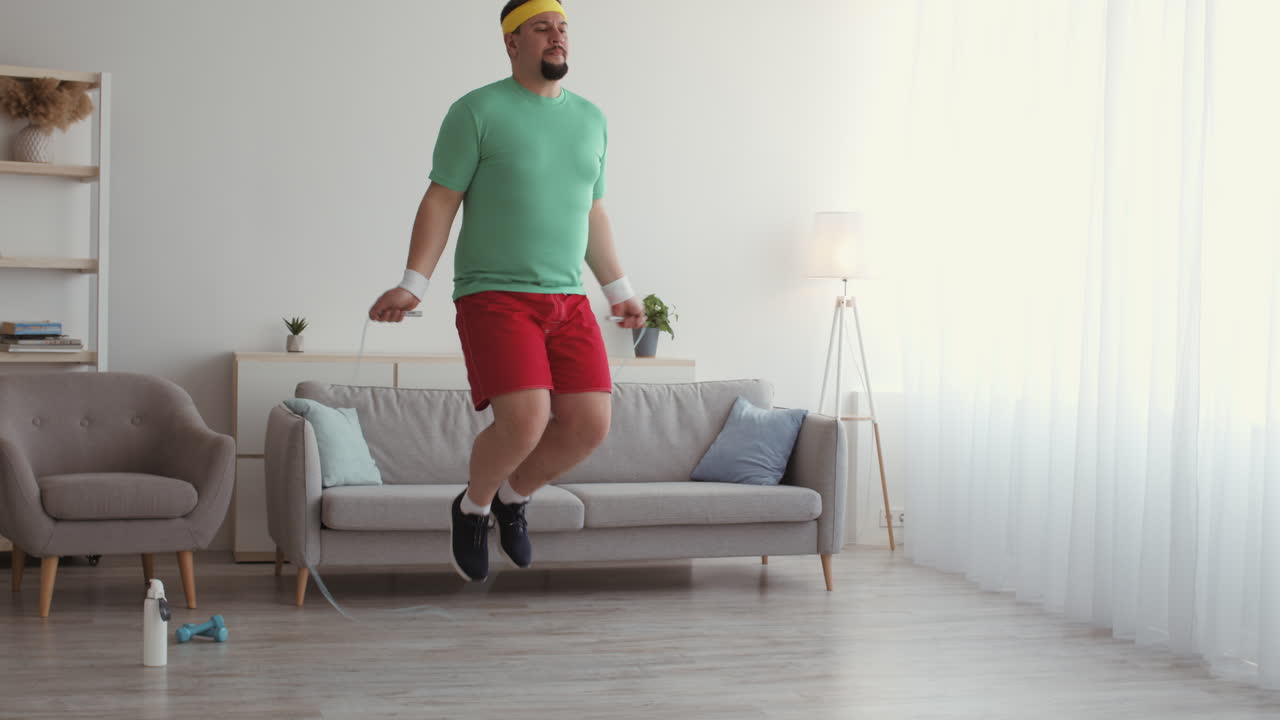 Uomo in sovrappeso divertente che salta la corda a casa