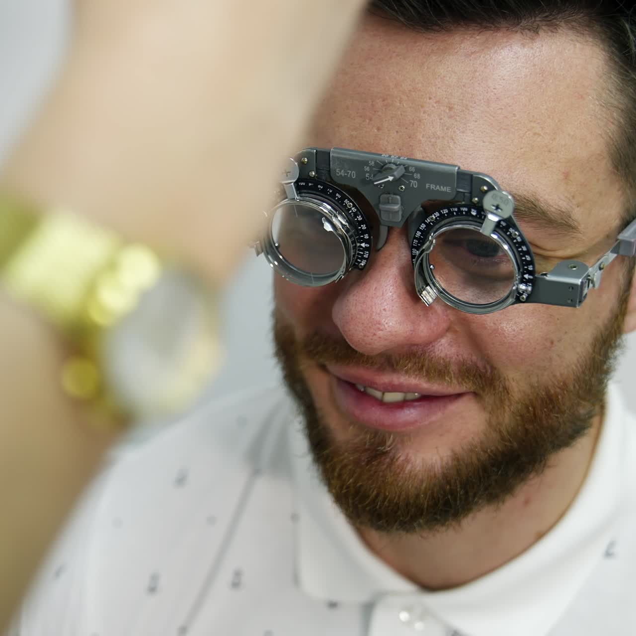 Smiling happy male patient in corrective testing glasses. Checking up eyesight in clinic. Handsome patient in ophthalmology