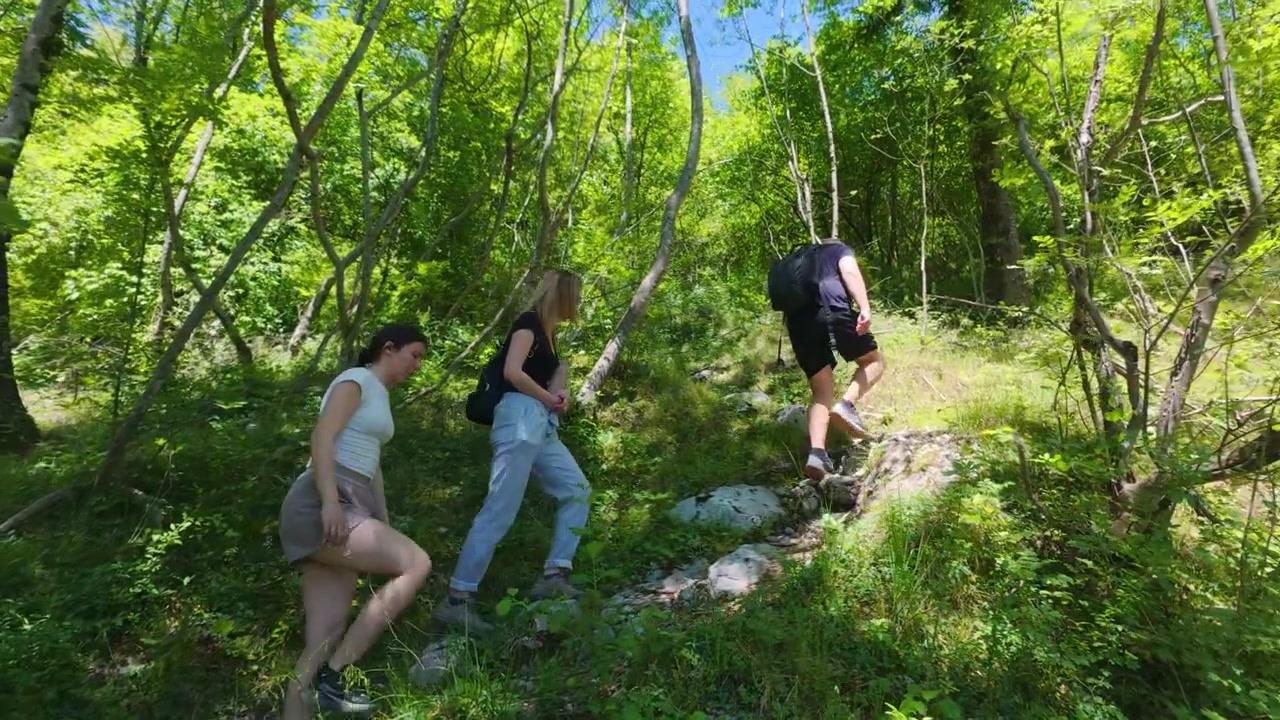 Giovani escursionisti che camminano in salita lungo un sentiero nel bosco nella regione di Posocje in Slovenia, ripresi in tracciamento