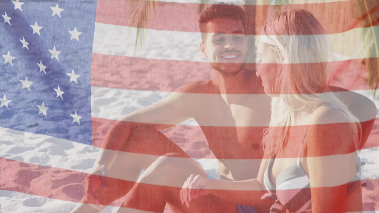 animación de la bandera estadounidense ondeando sobre una pareja sonriente enamorada en la playa