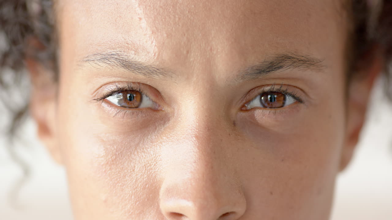 Close-up of woman's eyes looking confidently ahead, showing determination and focus, at home
