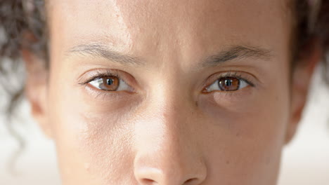 close-up of woman's eyes looking confidently ahead, showing determination and focus, at home