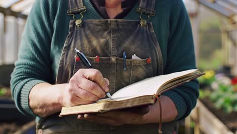 a gardener engaged in record-keeping, noting plant growth in a notebook within a lively greenhouse atmosphere, showcasing dedication to gardening and cultivation practices