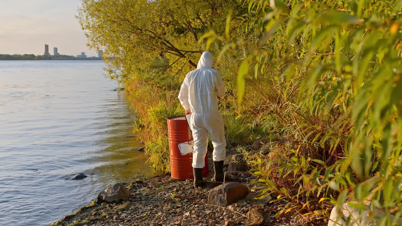 Ecologist In Full Personal Protective Equipment During Testing Of Water Quality In A Polluted Environment. Static Shot