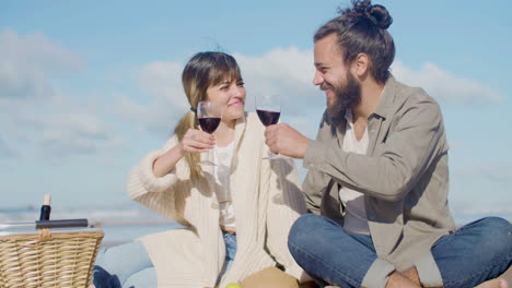 happy young couple enjoying picnic at seashore